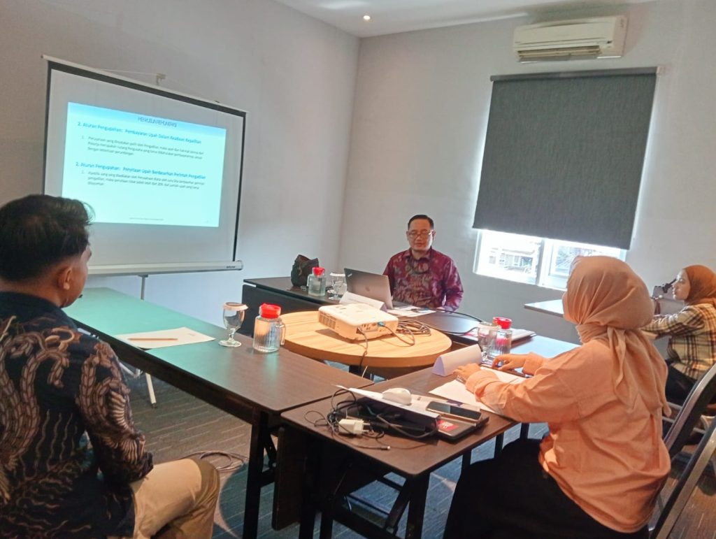 Suasana pelatihan penyusunan salary structure di Hotel Neo Dipatiukur, instruktur sedang menjelaskan aturan pengupahan kepada peserta.